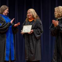 Faculty and Provost applauding awardee